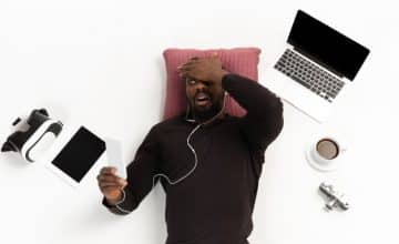 young man using phone surrounded by gadgets isolated 155003 37502
