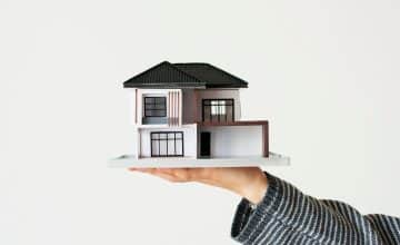 hand presenting model house home loan campaign