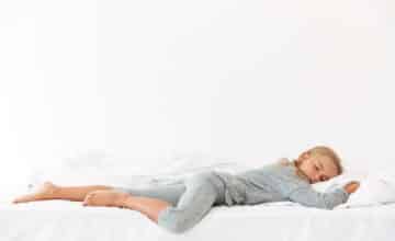 full length portrait sleeping peaceful girl gray pajamas lying bed