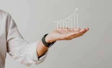 digital increasing bar graph with businessman hand overlay