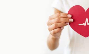 front view woman holding paper heart with heartbeat 1