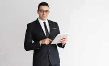 cheerful young businessman checking email tablet looking camera