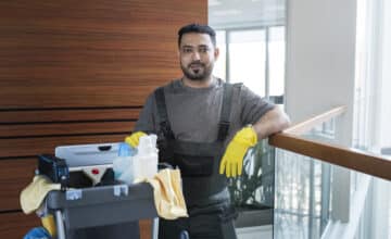 medium shot smiley man with cleaning cart