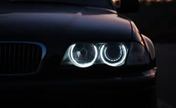 silhouette black sports car with headlights black background