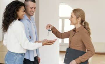 female realtor handing couple keys their new home