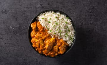 indian butter chicken black bowl black background