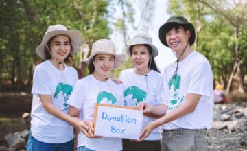 group asian diverse people volunteer holding donation box fundraiser emergency situation such as help ukraine flood victims food children charity eventvolunteering conceptual