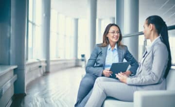 cheerful businesswoman talking her workmate