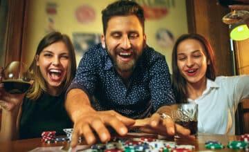side view photo friends sitting wooden table friends having fun while playing board game