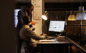 executive managers analyzing financial statistics discussing investment strategy while working overhours startup office businessmen planning brainstorming management ideas business concept