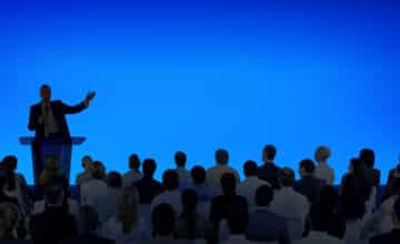 corporate businessman giving presentation large audience