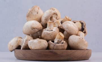bunch raw mushrooms wooden plate